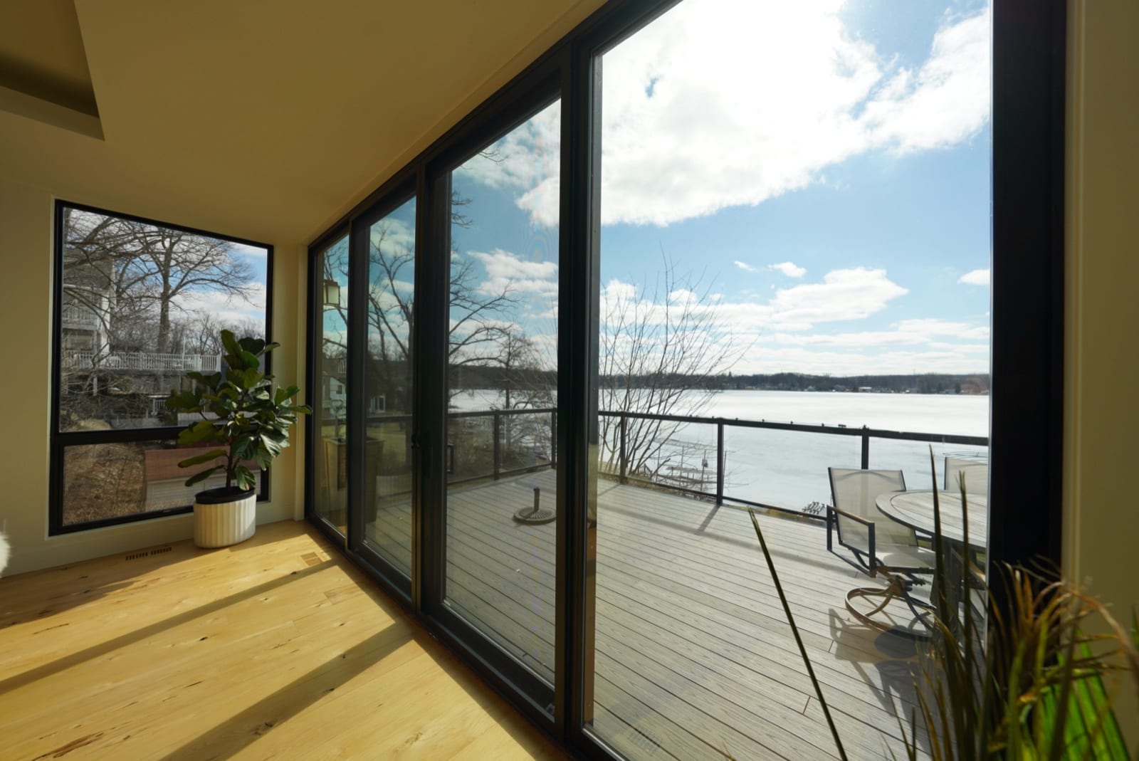 Floor-to-ceiling sliding doors with heat-control film overlooking a lake