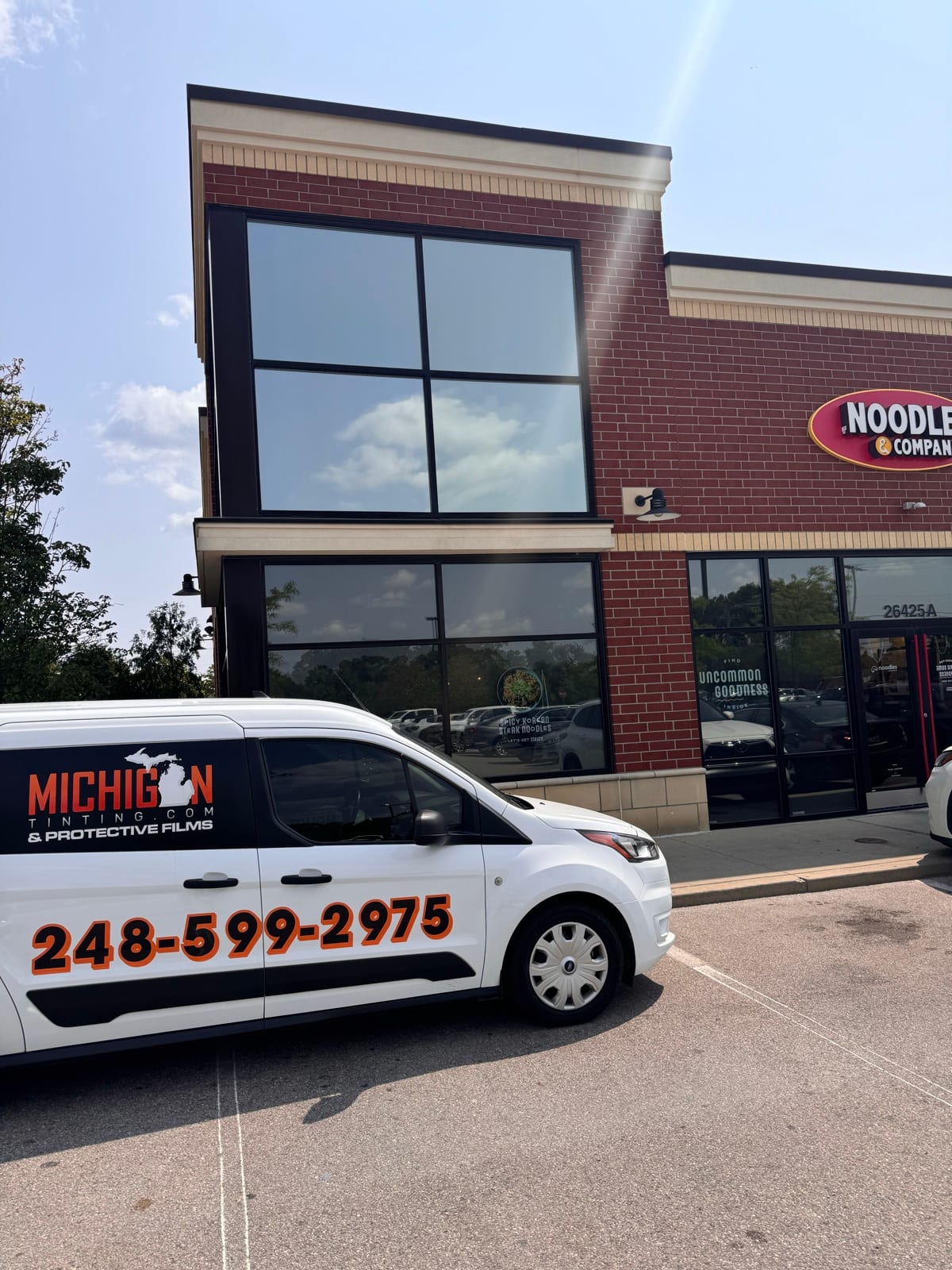 The company van outside a freshly tinted storefront